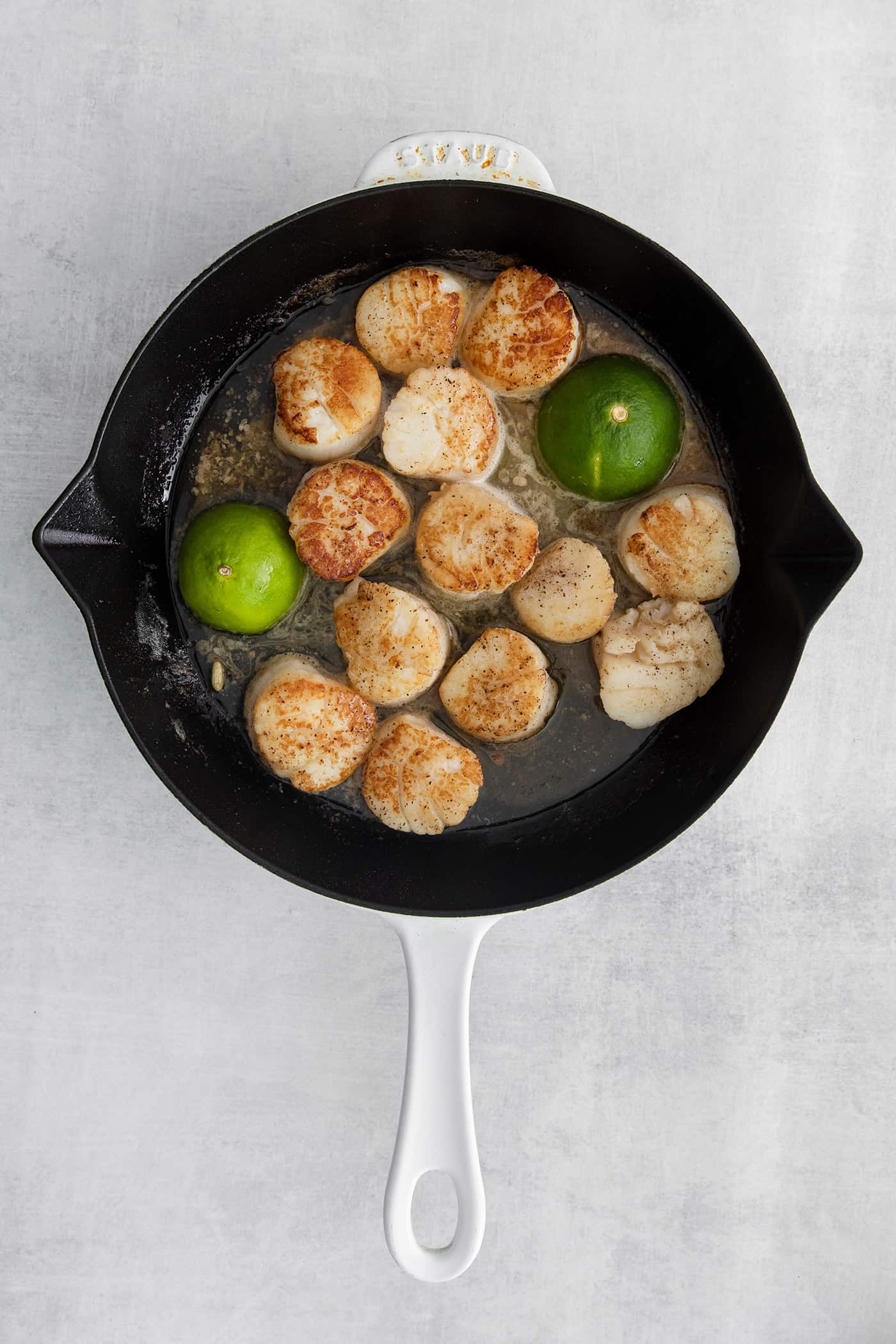 These Tex-Mex Scallop Rice Bowls are bright, refreshing, and packed with flavor, with scallops, pico de gallo, and lime crema. Seared scallops in a pan with lime halves