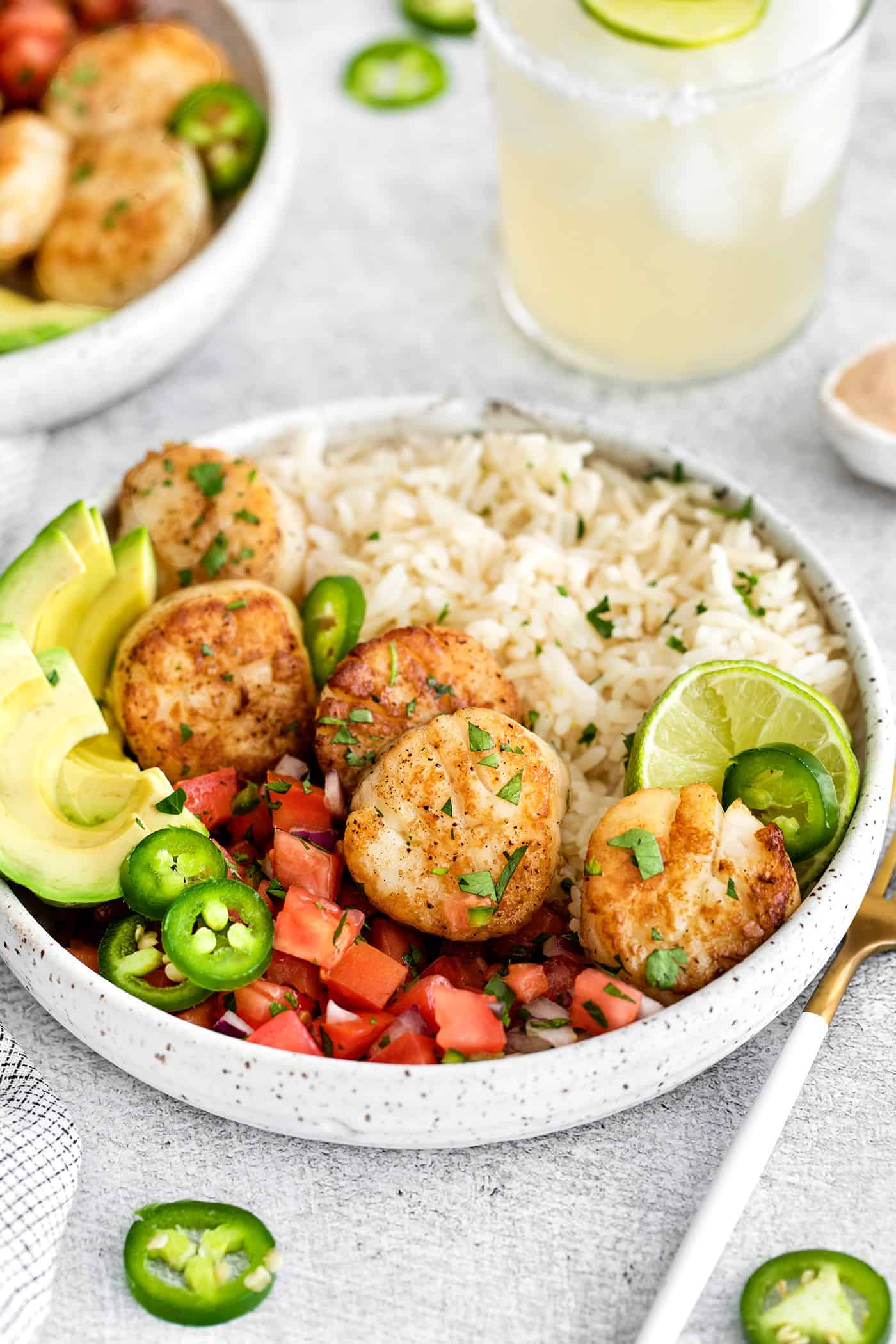 These Tex-Mex Scallop Rice Bowls are bright, refreshing, and packed with flavor, with scallops, pico de gallo, and lime crema. Overhead view of a Tex-Mex rice bowl