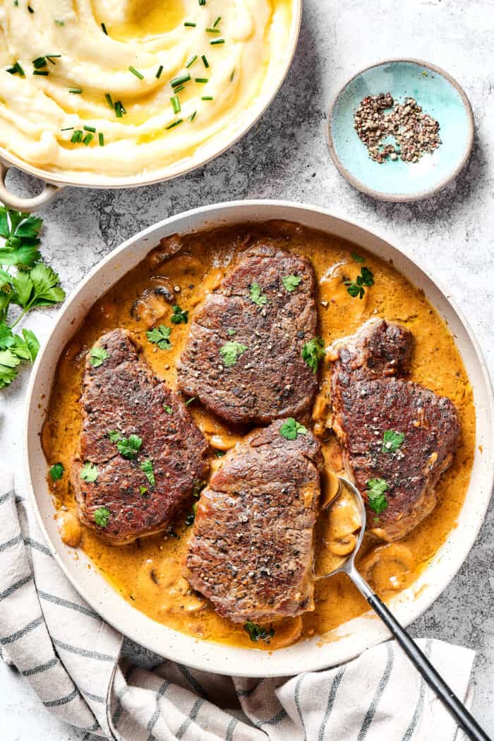 Steak Diane is a classic beef tenderloin recipe with pan-cooked steak in a creamy mushroom sauce. Simple but elegant & ready in 45 minutes. Steak diane in a pan