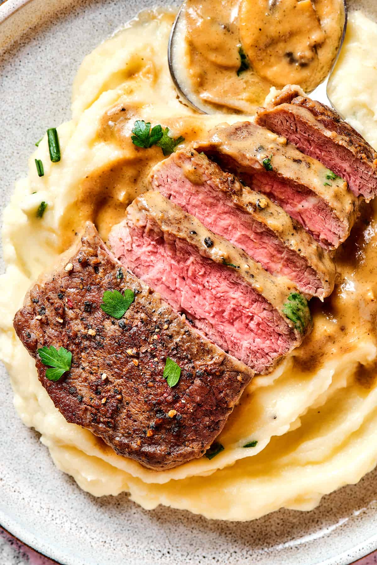 Steak Diane is a classic beef tenderloin recipe with pan-cooked steak in a creamy mushroom sauce. Simple but elegant & ready in 45 minutes. Sliced Steak Diane over mashed potatoes