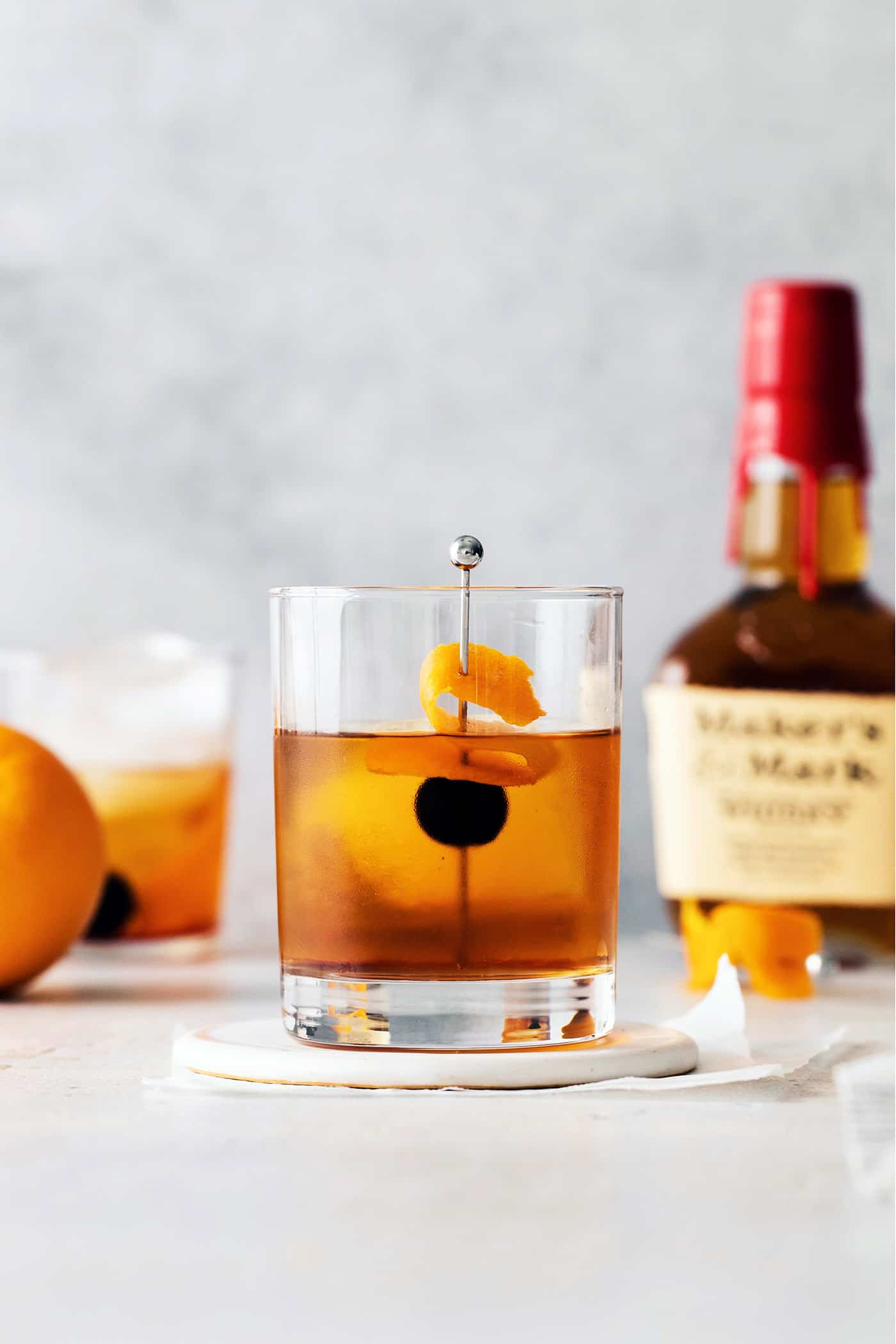 This classic Manhattan is a strong and earthy cocktail with just a hint of sweetness. Fancy and elegant, with 3 ingredients. A manhattan cocktail in front of a bottle of whiskey