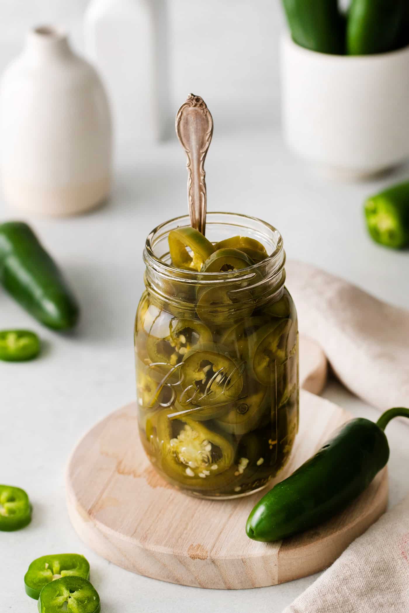 With just 5 ingredients, these Pickled Jalapenos are spicy and tangy. Add them to sandwiches and salads or straight from the jar. A jar of pickled jalapenos with a fork