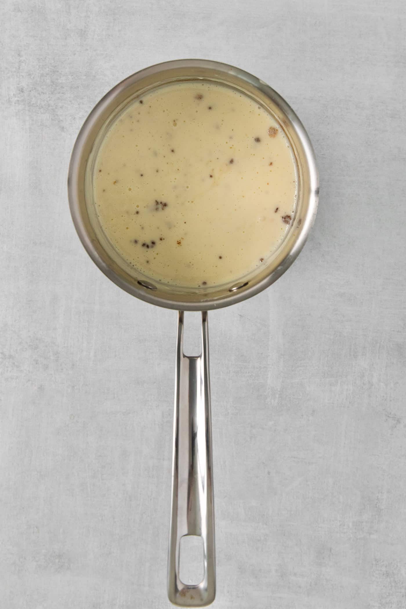 Smooth and creamy with just the right amount of heat, this Homemade Queso Blanco is made with just 5 ingredients! Quick & easy! Overhead view of white cheese dip in a saucepan