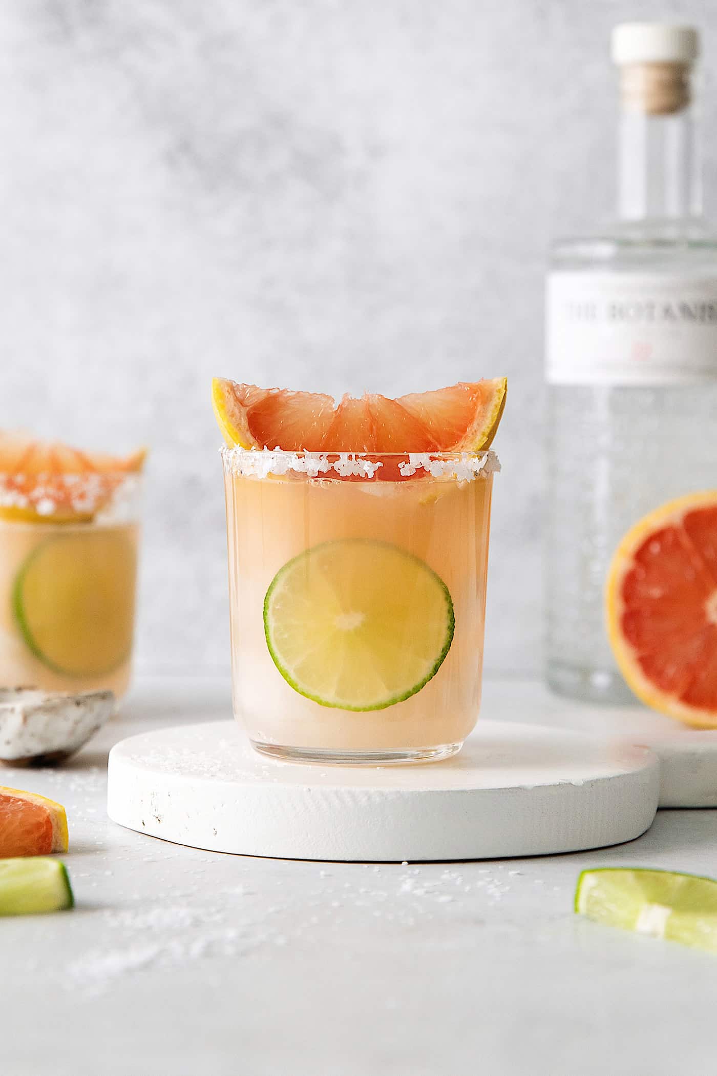 This Salty Dog cocktail is a twist on a classic greyhound that features gin and a coarse salt rim. The cocktail is fruity and refreshing. A salty dog drink on a slab of marble