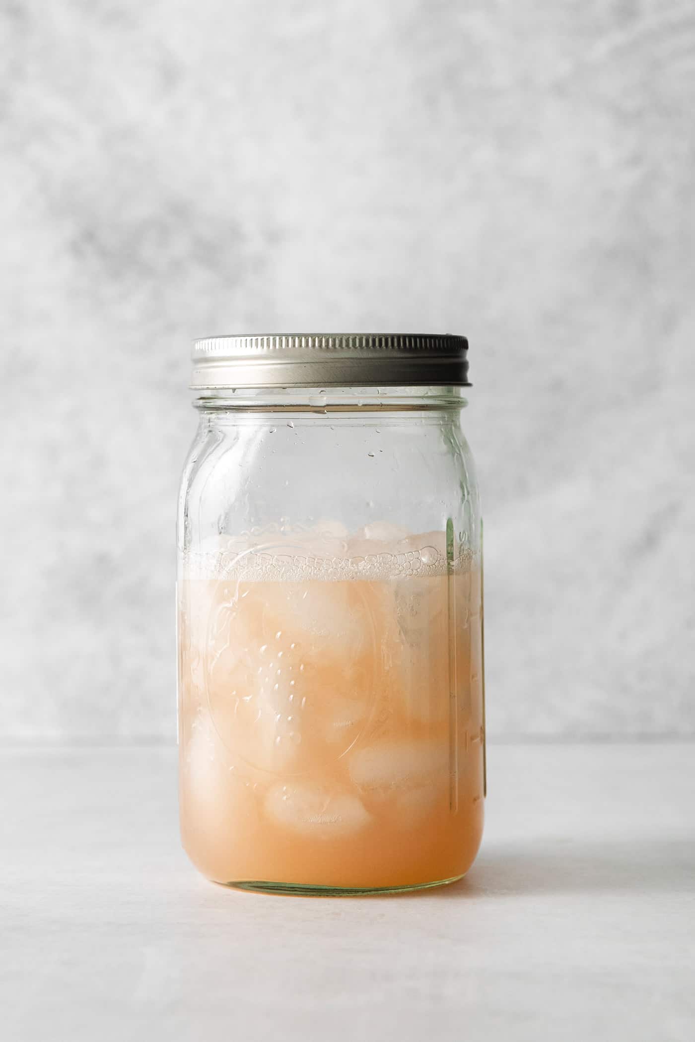 This Salty Dog cocktail is a twist on a classic greyhound that features gin and a coarse salt rim. The cocktail is fruity and refreshing. Grapefruit cocktail in a mason jar