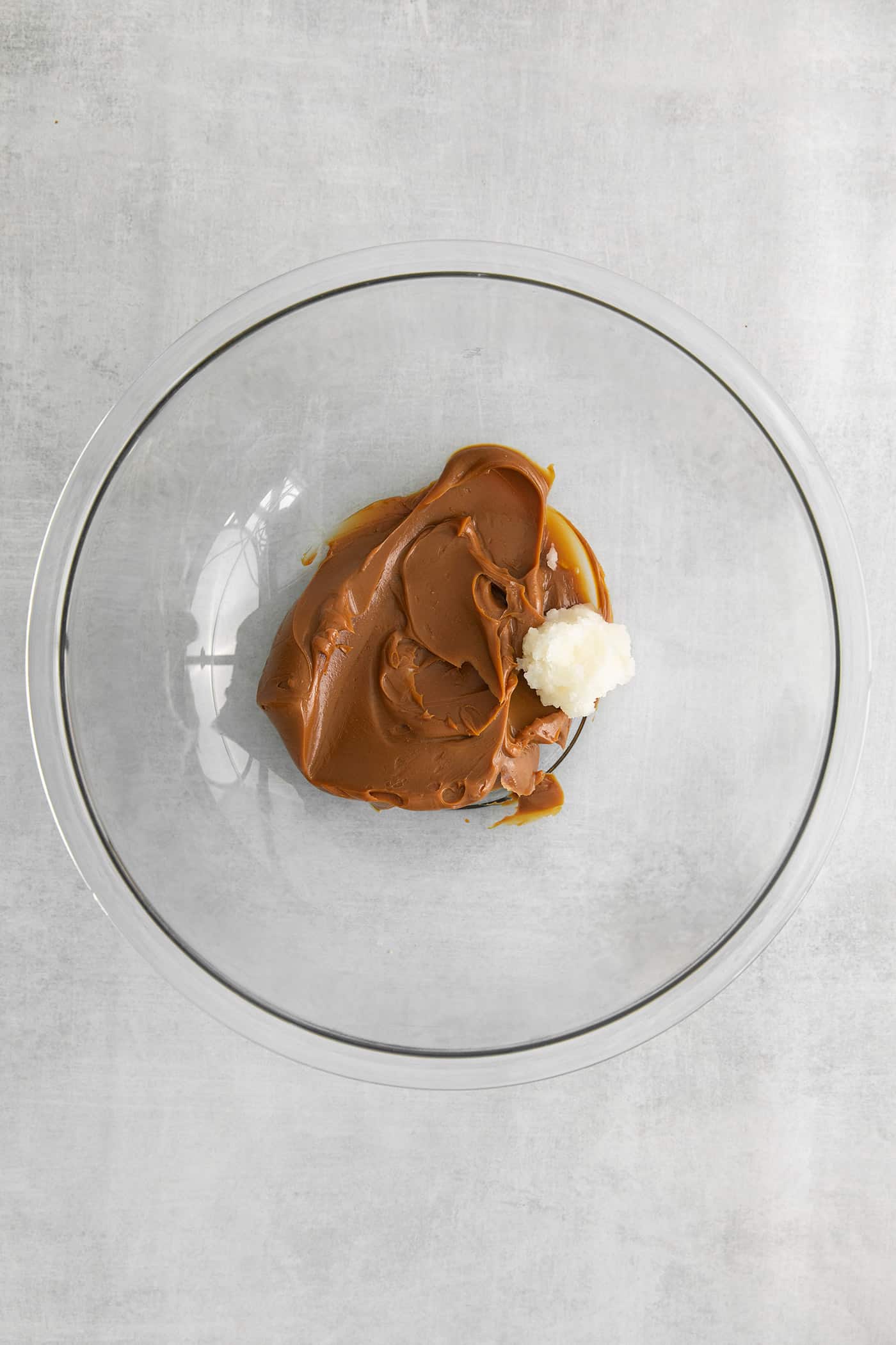 These Samoa Macaroons are rich and nutty, made with toasted coconut and dulce de leche and then dipped in chocolate. Dulce de leche in a bowl with coconut oil
