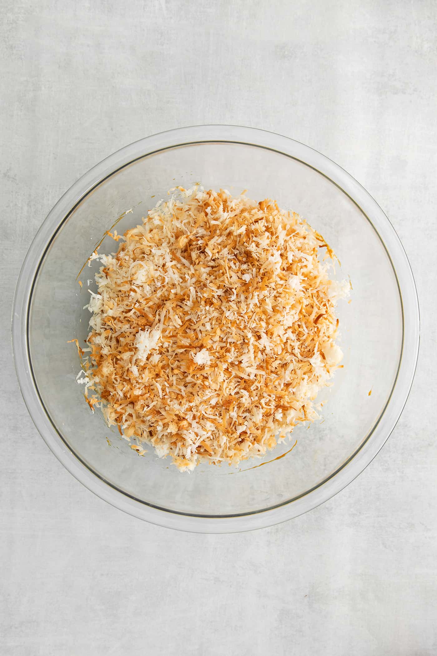 These Samoa Macaroons are rich and nutty, made with toasted coconut and dulce de leche and then dipped in chocolate. Toasted coconut in a bowl