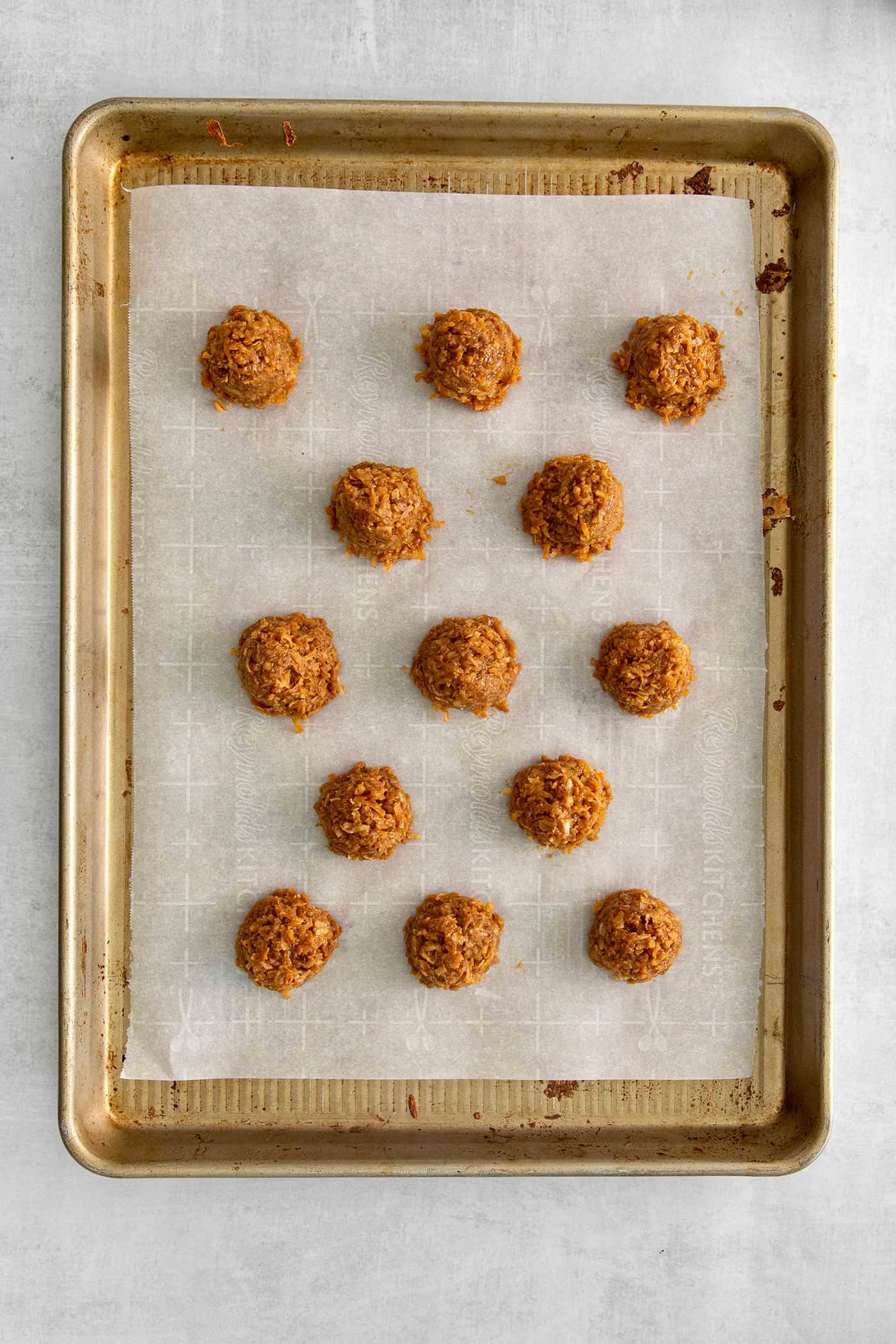 These Samoa Macaroons are rich and nutty, made with toasted coconut and dulce de leche and then dipped in chocolate. Dulce de leche macaroons on a baking sheet