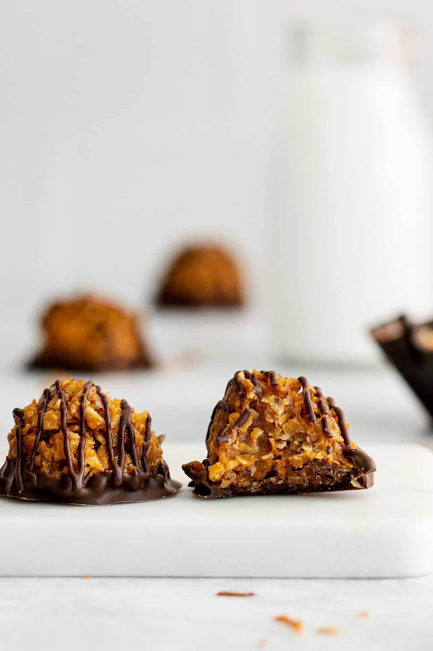 These Samoa Macaroons are rich and nutty, made with toasted coconut and dulce de leche and then dipped in chocolate. Two chocolate dipped dulce de leche macaroons