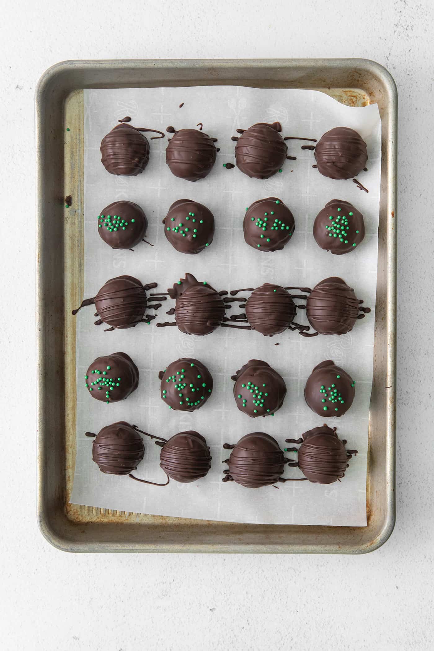Made with your favorite Girl Scout cookies, these Thin Mint Truffles are the perfect combination of rich chocolate and mint flavor. Overhead view of thin mint truffles on a baking sheet
