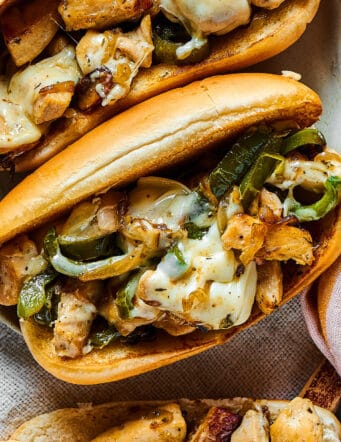 overhead photo of assembled sandwich with a hoagie roll, chicken, green pepper, and melted cheese
