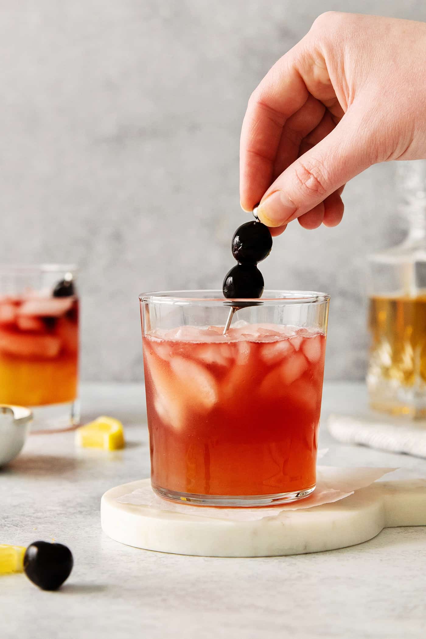 This New York Sour is made with whiskey, freshly squeezed lemon juice, simple syrup, and fruity red wine. Perfectly sweet & tart. Stirring a New York Sour with a toothpick garnish