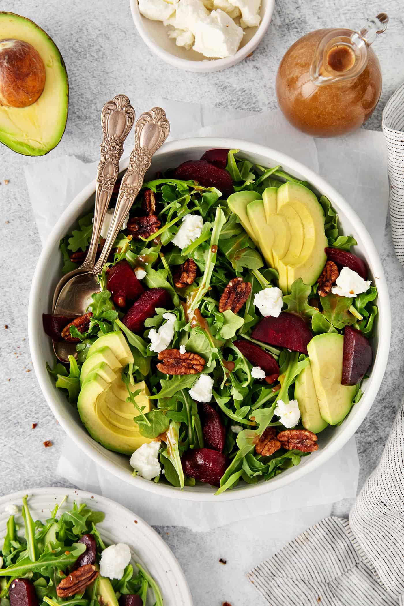 Topped with goat cheese, avocado, and candied pecans, this Arugula Beet Salad offers the perfect combination of flavors. Overhead view of a bowl of arugula goat cheese salad
