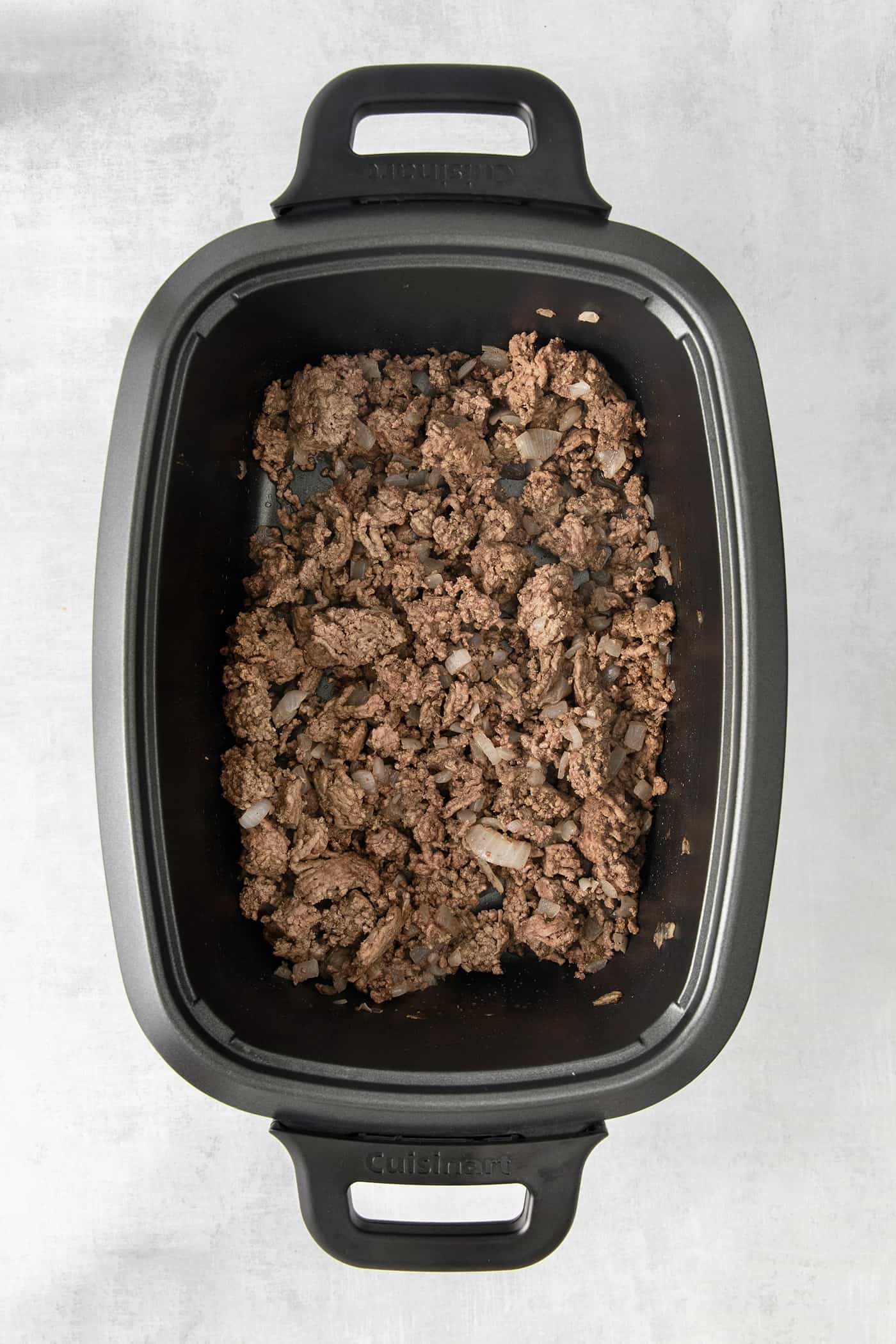 Slow Cooker Sloppy Joes are super flavorful, easy to make, and great for feeding a crowd. Serve on sandwich buns for a quick meal anytime. Cooked ground beef in the bottom of a slow cooker
