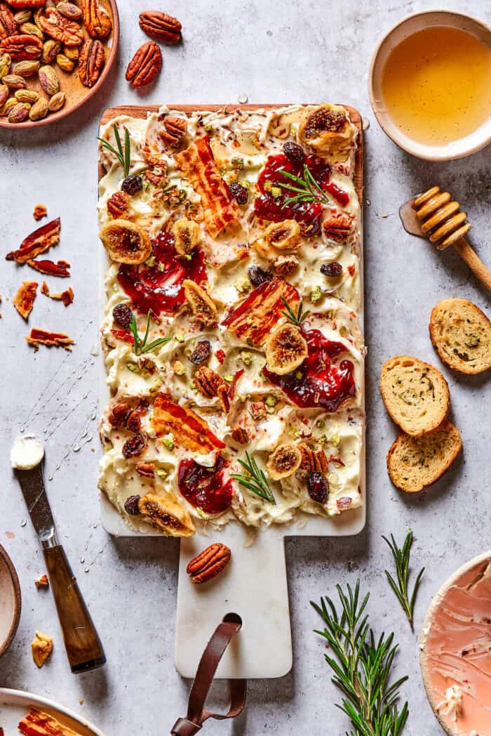 This Butter Board with Bacon Butter features toppings like dried fruits, nuts, and honey for an easy, savory butter charcuterie board. Overhead view of a butter charcuterie board with bacon
