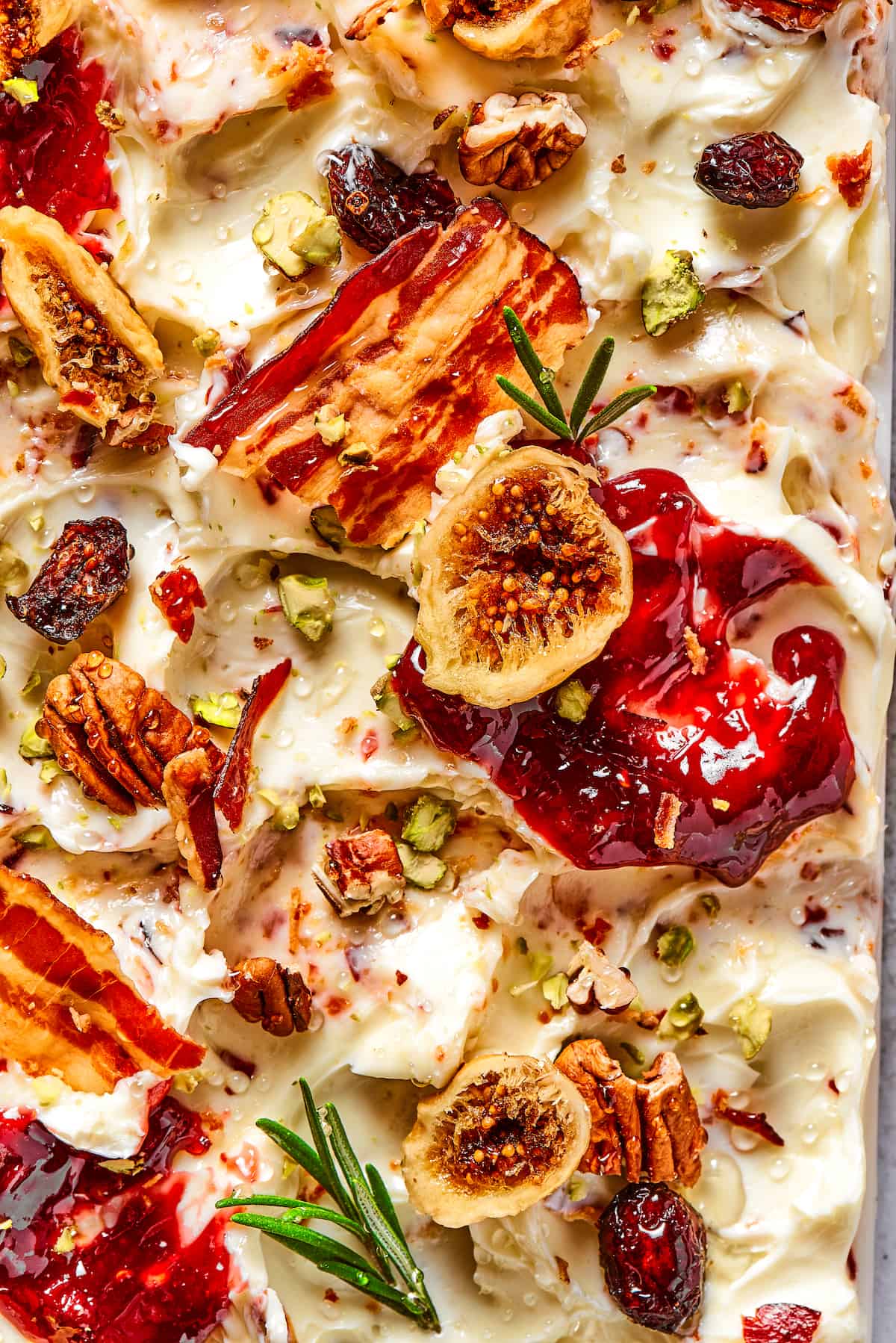 This Butter Board with Bacon Butter features toppings like dried fruits, nuts, and honey for an easy, savory butter charcuterie board. Close up of a butter board with bacon, dried fruits, and jam