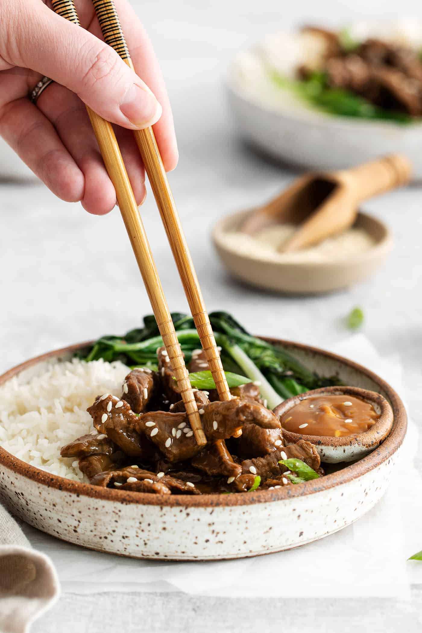 These Beef Bulgogi Rice Bowls are an easy copycat of your favorite Korean BBQ! Flavorful beef bulgogi is served with crisp bok choy and rice. Chopsticks diving into a beef bulgogi rice bowl