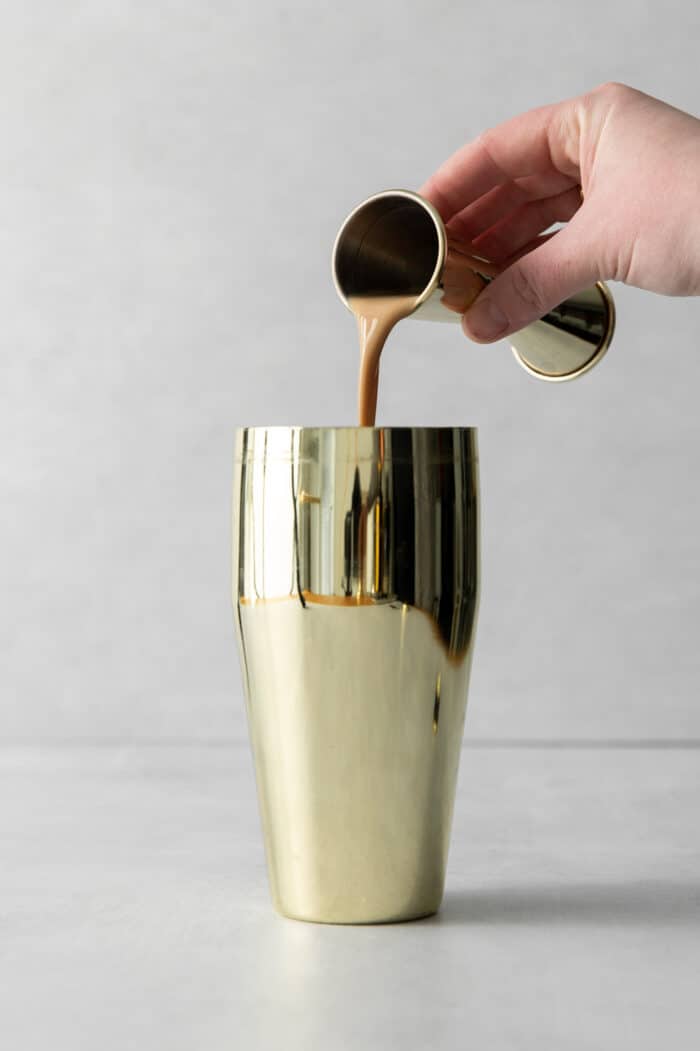 Made with espresso, vodka, and two liqueurs, this Espresso Martini is a strong coffee cocktail that's sure to provide an afternoon boost. Kahlua being poured into a shaker