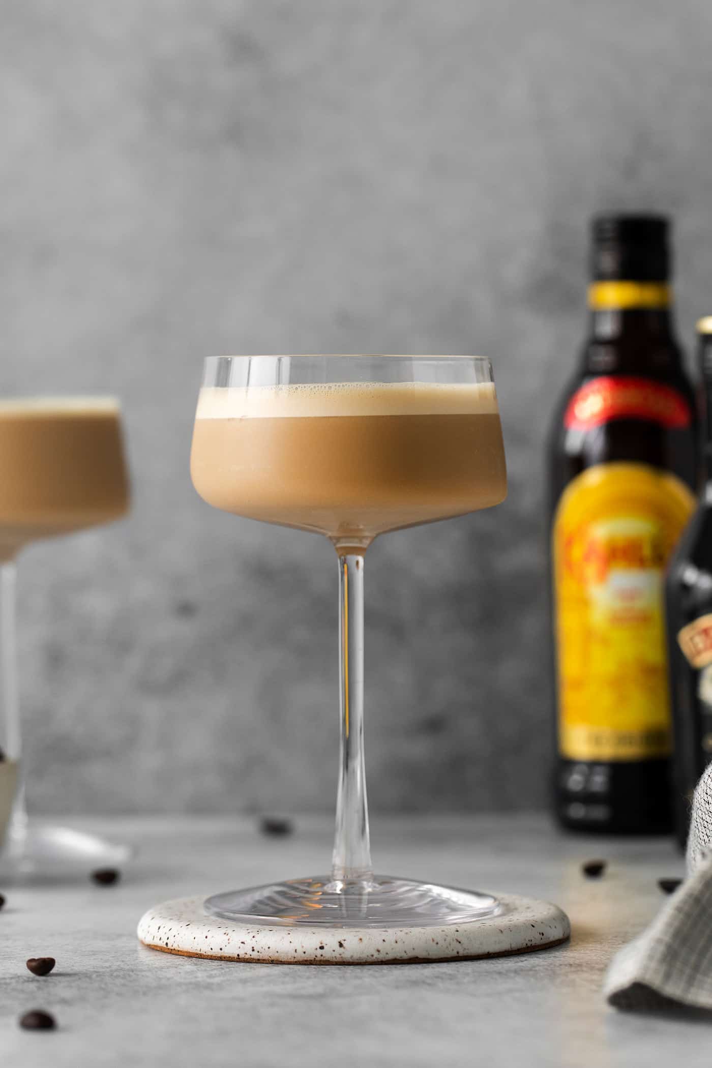 Made with espresso, vodka, and two liqueurs, this Espresso Martini is a strong coffee cocktail that's sure to provide an afternoon boost. Side view showing the layers of an espresso martini