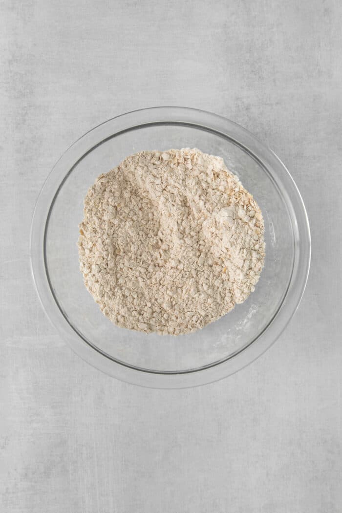 These Oatmeal Cream Pies are just like the classic store-bought variety, where a layer of sweet cream is sandwiched by chewy oatmeal cookies. Dry cookie dough ingredients in a mixing bowl