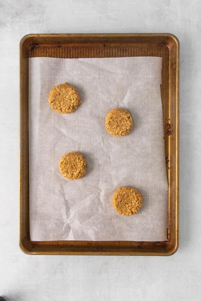 These Oatmeal Cream Pies are just like the classic store-bought variety, where a layer of sweet cream is sandwiched by chewy oatmeal cookies. Oatmeal cookies on a baking sheet