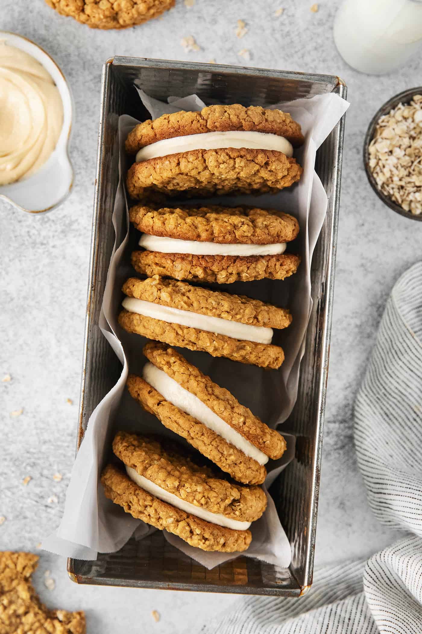 These Oatmeal Cream Pies are just like the classic store-bought variety, where a layer of sweet cream is sandwiched by chewy oatmeal cookies. Overhead view of oatmeal creme pies on their side