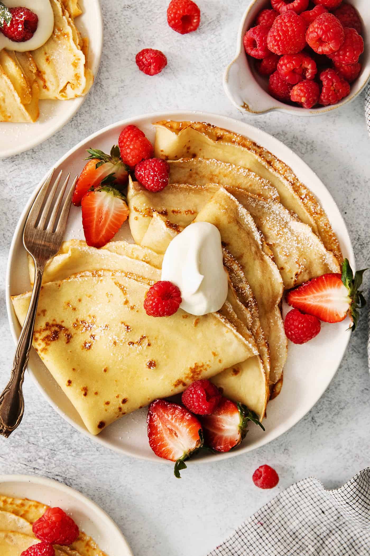 Make French crepes this Mother's Day and treat mom to an elegant, melt-in-your-mouth brunch dish with continental flair. A plate of French crepes topped with fruit on a table.