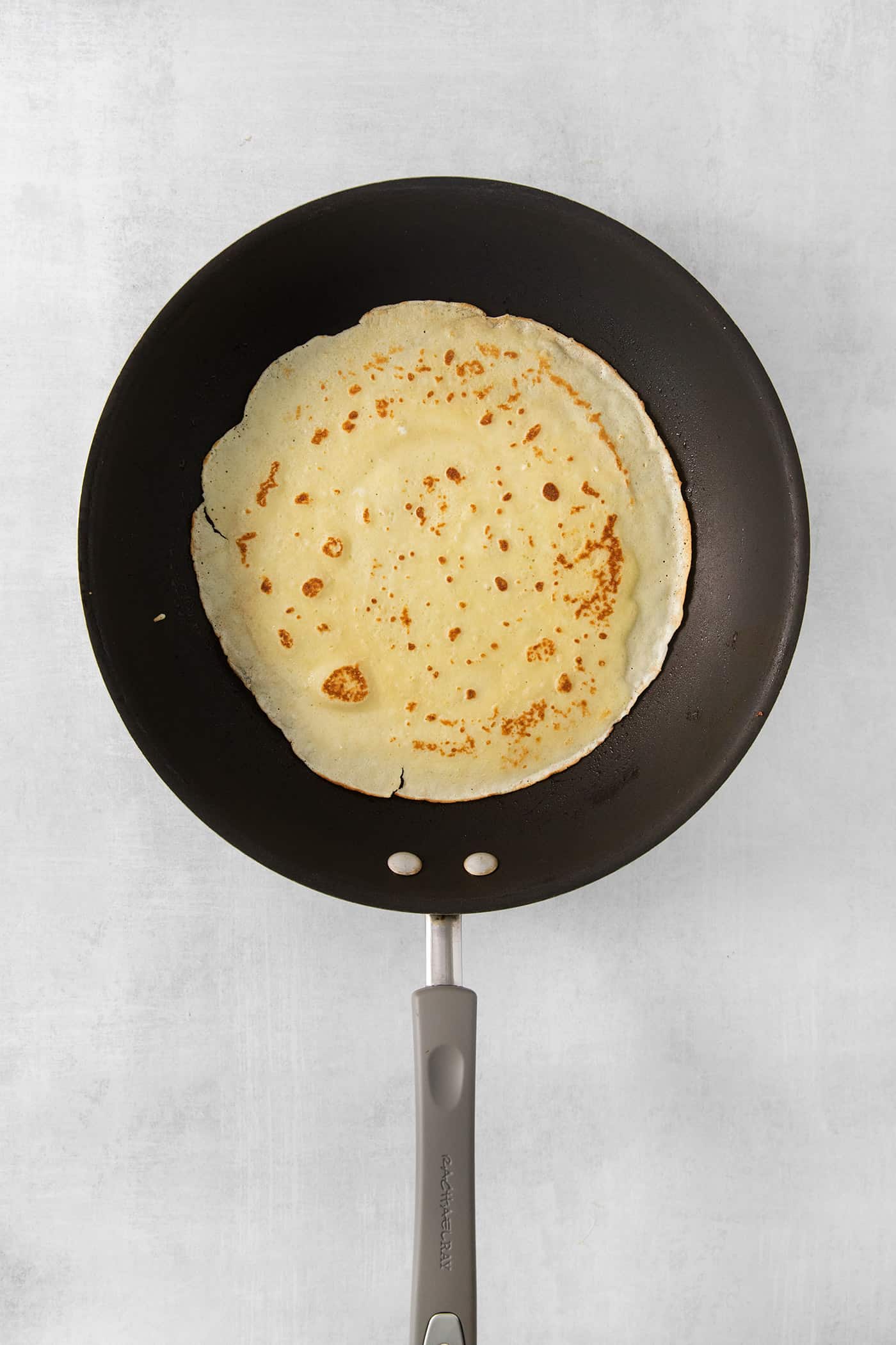 Make French crepes this Mother's Day and treat mom to an elegant, melt-in-your-mouth brunch dish with continental flair. Cooking a crepe in a pan.