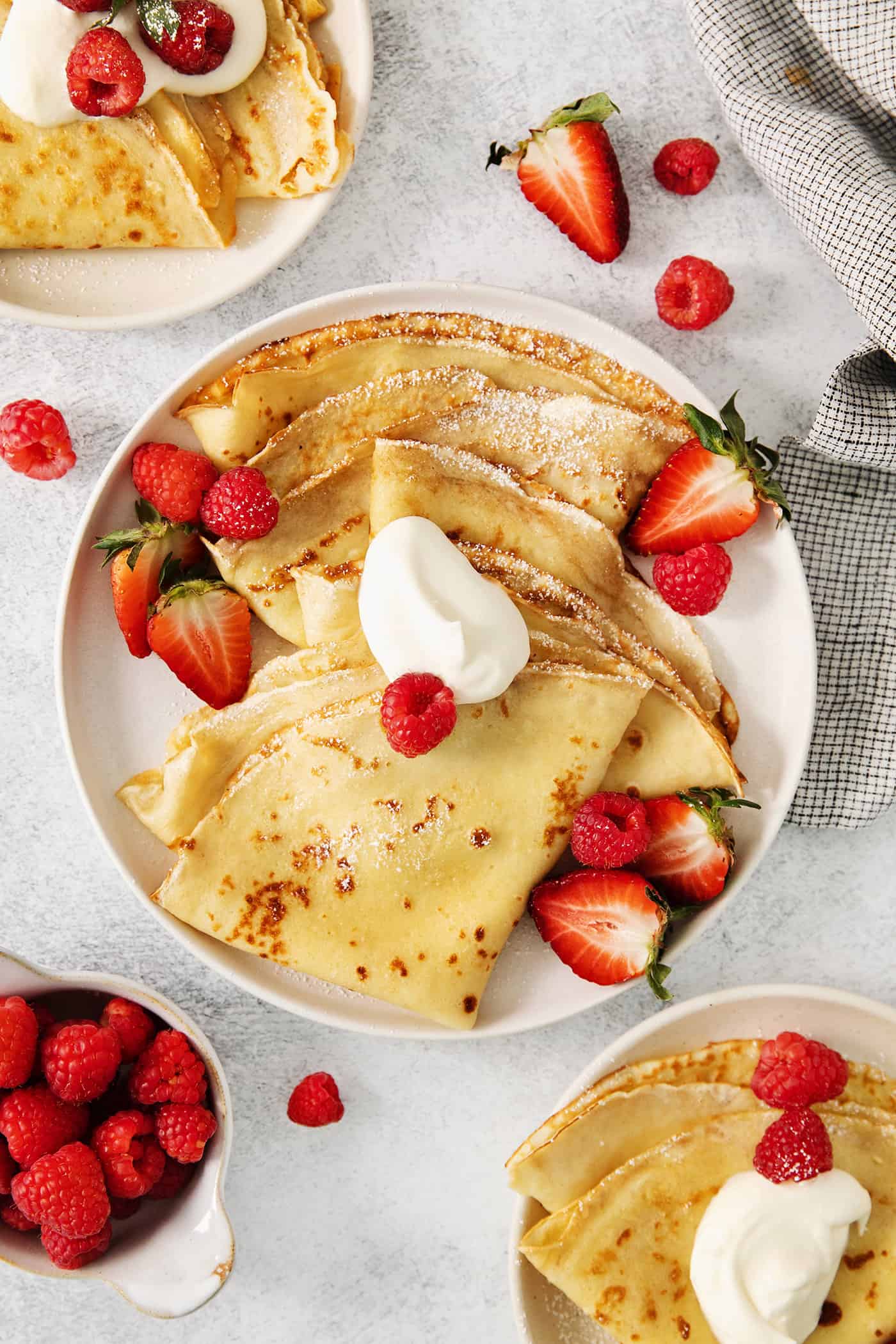 Make French crepes this Mother's Day and treat mom to an elegant, melt-in-your-mouth brunch dish with continental flair. A plate of French crepes topped with strawberries on a table.