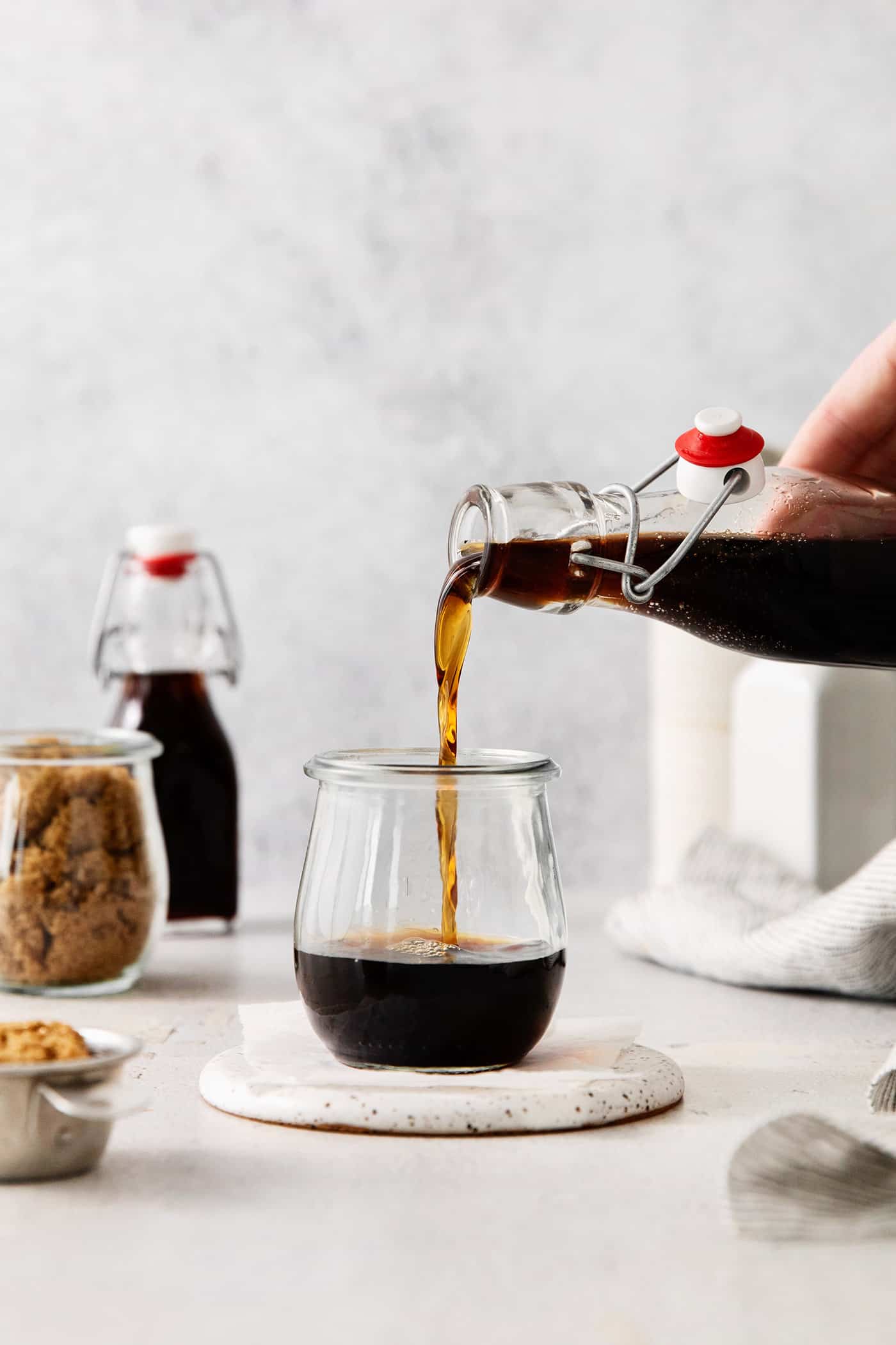 This Brown Sugar Syrup is quick and easy to prepare, with just 3 ingredients - water, brown sugar, and salt. Brown sugar syrup being poured into a glass