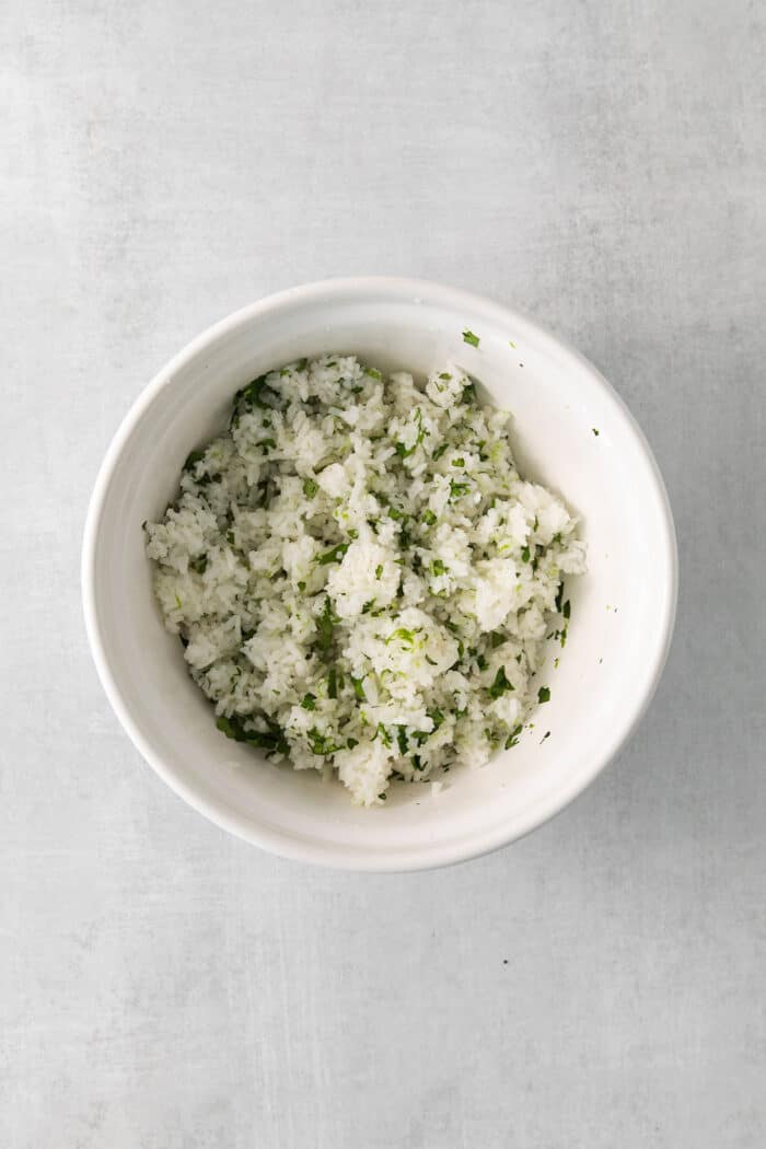 Cilantro Lime Rice is the perfect base or side for so many recipes. The rice is perfectly cooked and seasoned with hints of lime & cilantro. Cilantro lime rice mixed in a bowl