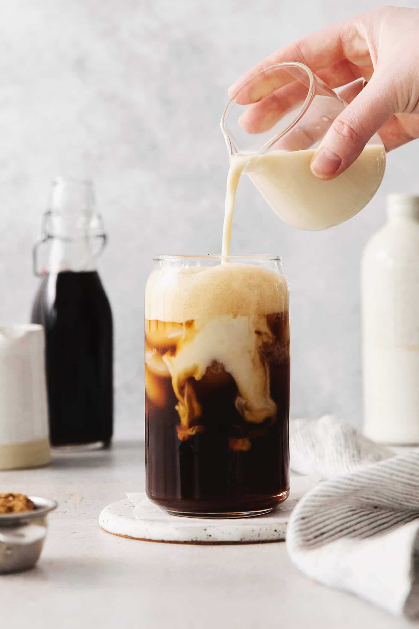 Made with just 4 ingredients, this Iced Brown Sugar Oatmilk Shaken Espresso tastes just like the Starbucks version! Oatmilk being poured into a brown sugar shaken espresso