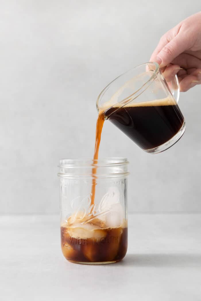 Made with just 4 ingredients, this Iced Brown Sugar Oatmilk Shaken Espresso tastes just like the Starbucks version! Espresso being poured into a pint jar