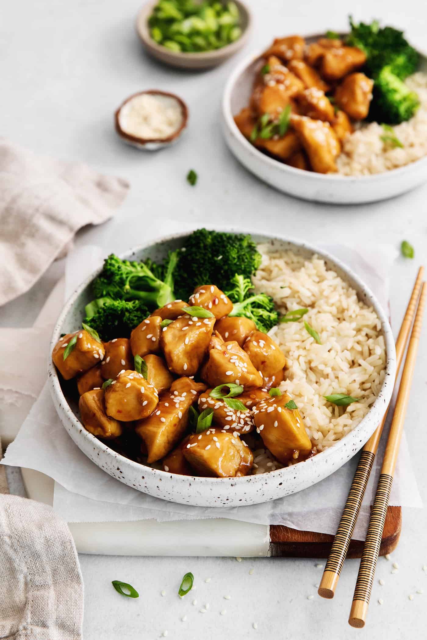 Inspired by Chinese takeout, this Mandarin Chicken is tender and juicy, coated in a sweet and sticky sauce. Ready in 30 minutes! Angled view of two plates of mandarin orange chicken