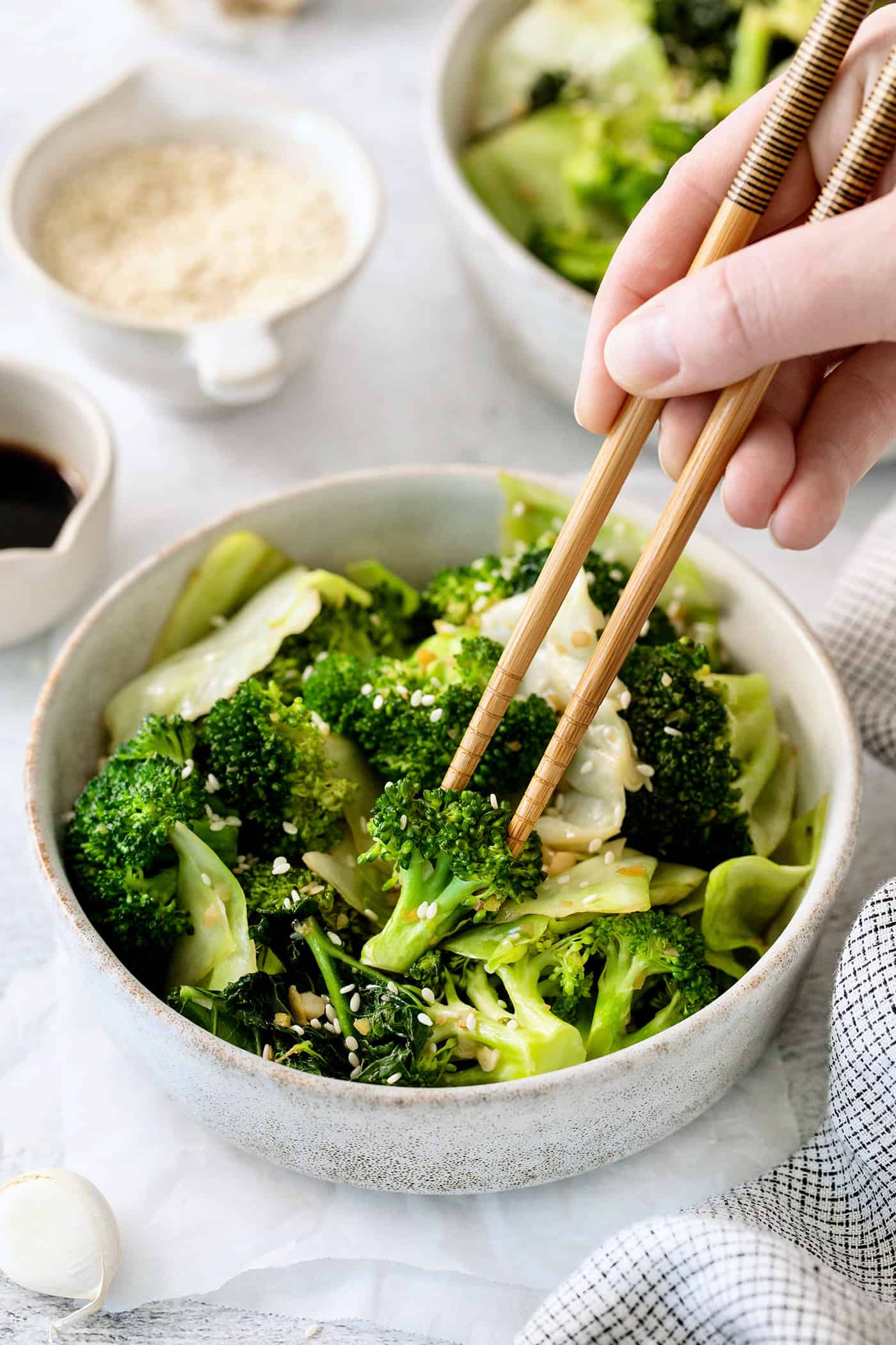 Panda Express Super Greens are a fresh, bright, feel-good side dish made with broccoli, cabbage, and kale in a light garlic-ginger soy sauce. Chopsticks in a bowl of Panda Express super greens