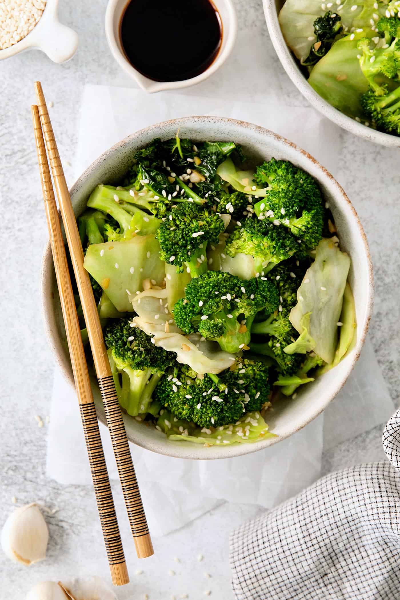 Panda Express Super Greens are a fresh, bright, feel-good side dish made with broccoli, cabbage, and kale in a light garlic-ginger soy sauce. Overhead view of a bowl of Panda express super greens with chopsticks laying across the bowl