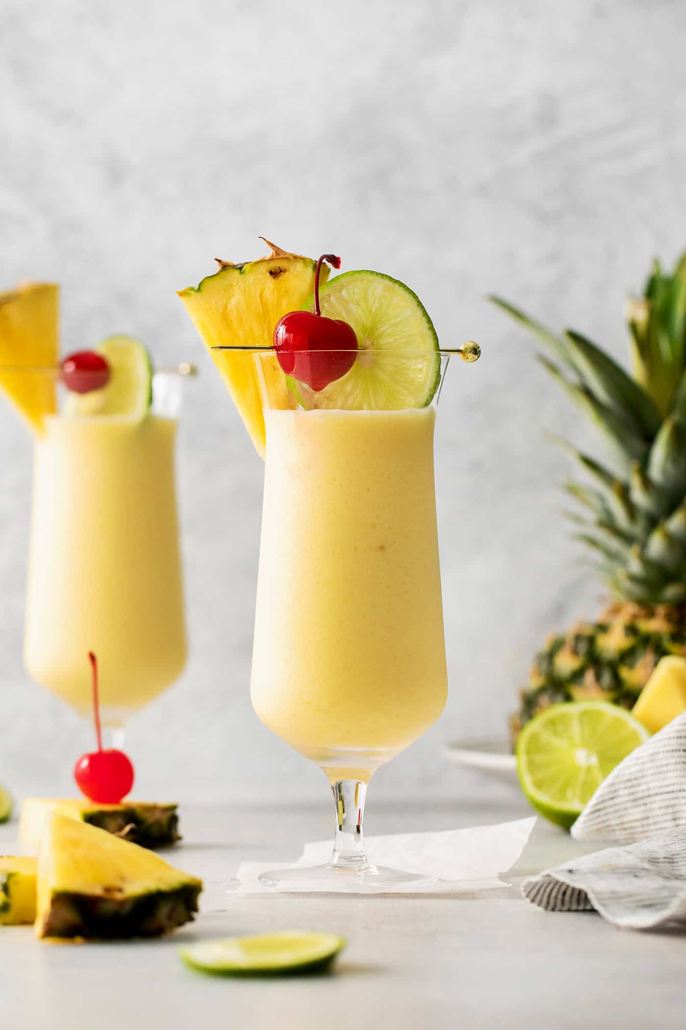 This Classic Pina Colada is fruity and refreshing, with sweet pineapple, a hint of lime, and plenty of rum. The perfect cocktail for summer! Front view of a pina colada cocktail