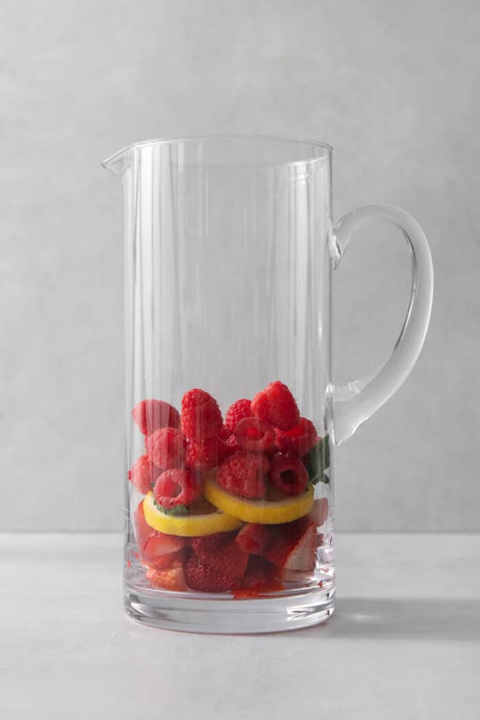 Fruit is shown in a glass pitcher.