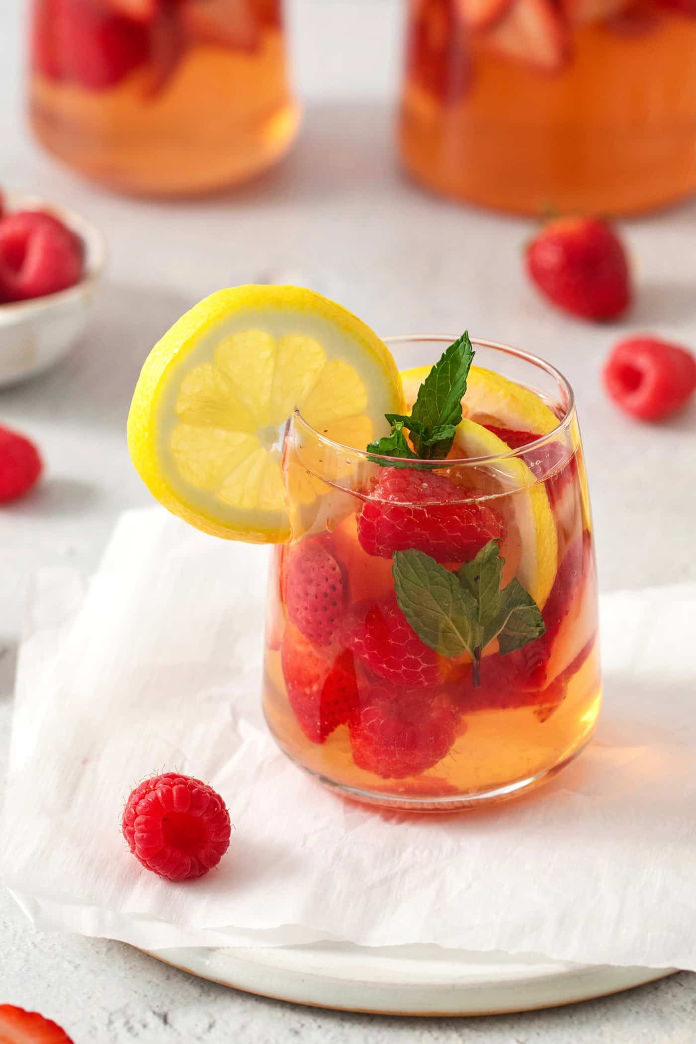 A glass of rose sangria and a lemon slice.