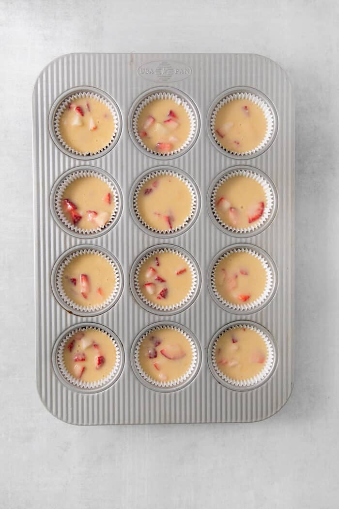 Vibrantly pink Strawberry Cupcakes will dress up your Mother's Day table - or make them anytime for a special strawberry treat. Strawberry cupcake batter is shown in a cupcake tin.