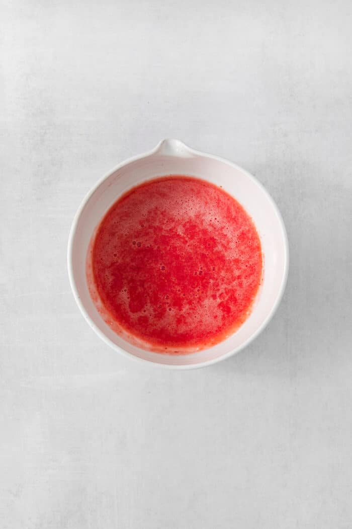 Vibrantly pink Strawberry Cupcakes will dress up your Mother's Day table - or make them anytime for a special strawberry treat. Pureed strawberries are shown in a white bowl.