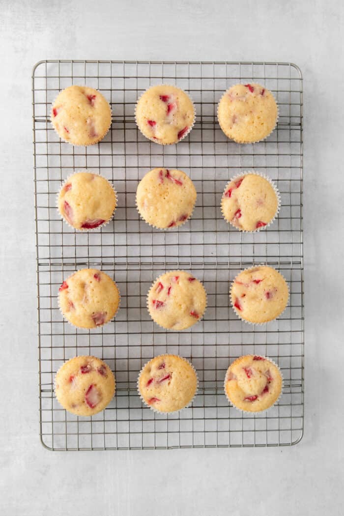 Vibrantly pink Strawberry Cupcakes will dress up your Mother's Day table - or make them anytime for a special strawberry treat. An overhead photo of a dozen unfrosted strawberry cupcakes.