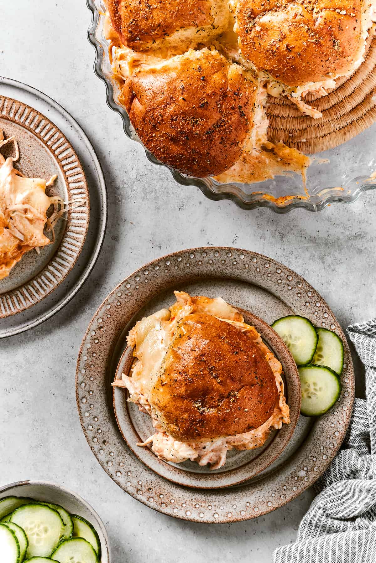 Buffalo Chicken Sliders are hand-held bites of spicy goodness! Loaded with melted cheese and creamy ranch, these are sure to be a hit. Buffalo chicken sliders are shown on plates.
