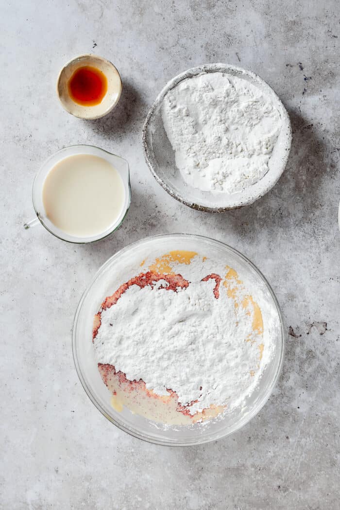 Creamy and sweet with a bit of crunch, Strawberry Crunch Cake is bursting with fruit flavor! This bright strawberry dessert is a favorite. Mixing the flour with the wet mixture in bowls.