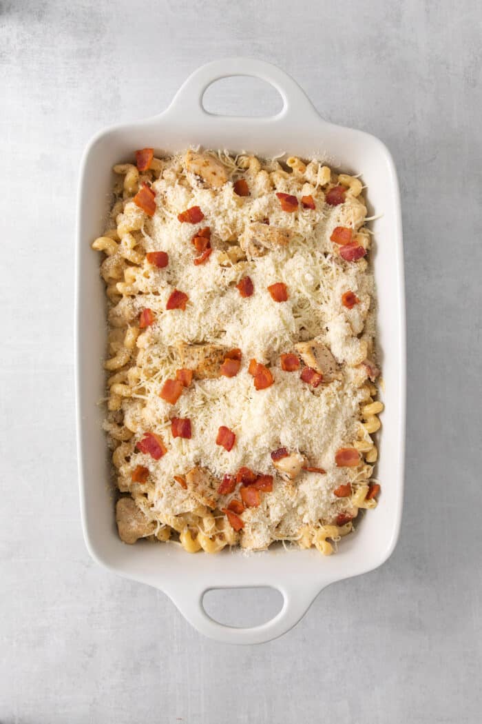 This Chicken Bacon Ranch Pasta is a perfect family-friendly meal loaded with flavor! Bacon, chicken, and pasta are baked in a creamy sauce. Chicken ranch pasta in a baking dish is covered with cheese and bacone.