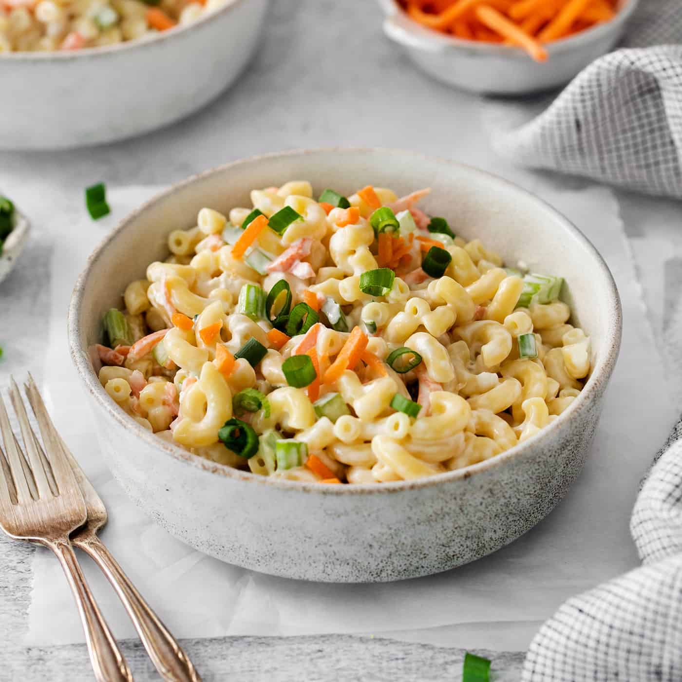 Hawaiian Macaroni Salad is always a hit at summer barbecues! It's a quick and easy side dish that goes perfectly with grilled meats. A white bowl of hawaiian macaroni salad on a table.