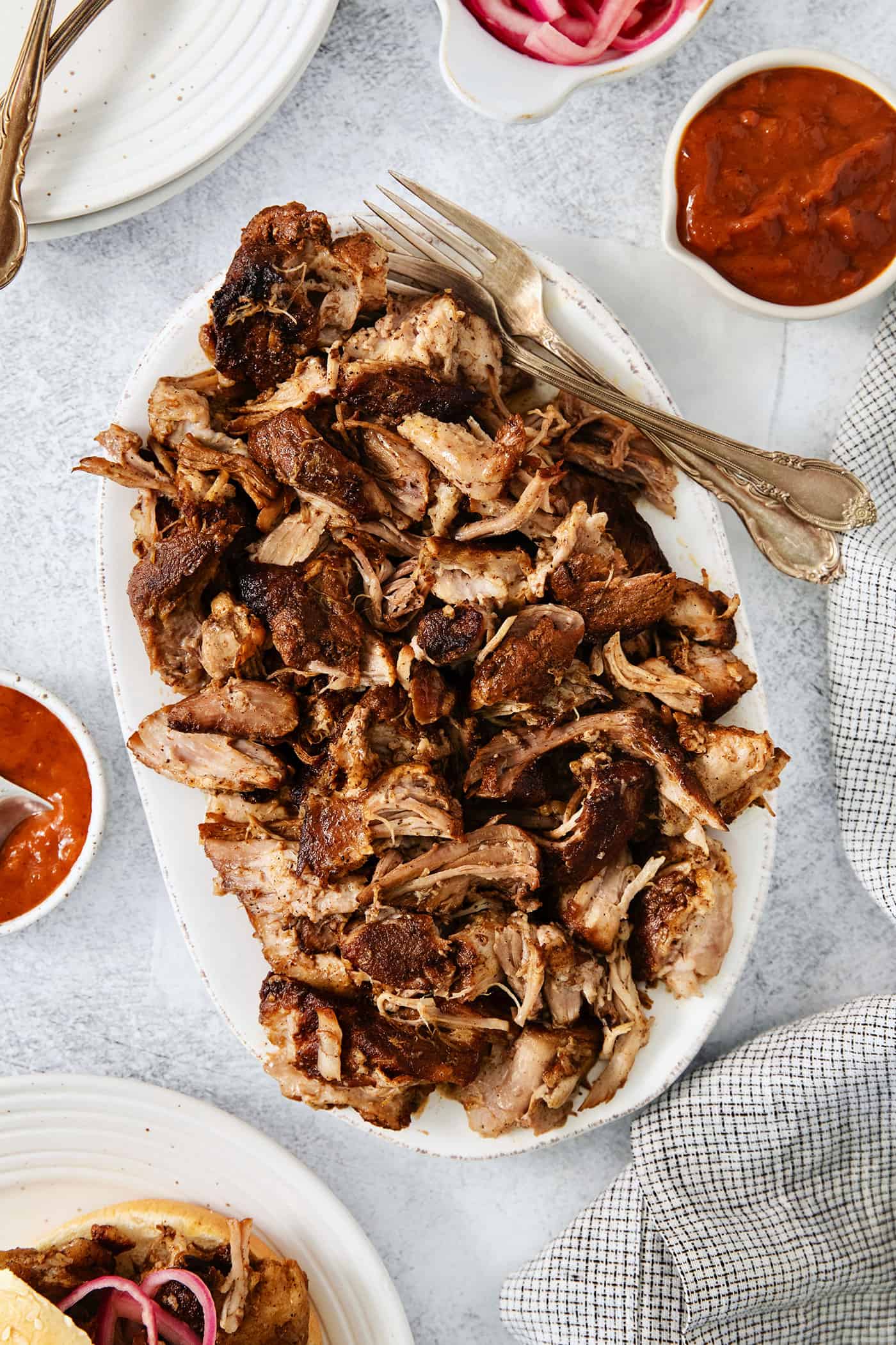 Incredibly tender and a little bit spicy, this easy Pulled Pork recipe is an absolute keeper. It's also super flavorful and versatile. A platter of pulled pork.