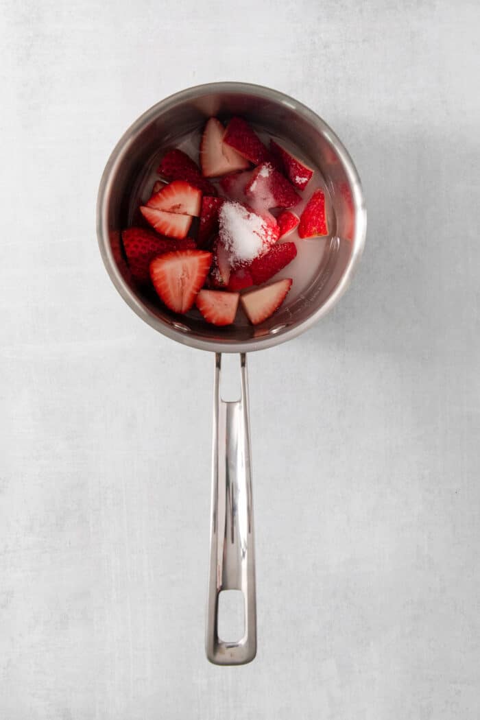 Refreshing and beautiful, Strawberry Milk is beyond simple to make! You'll need just 4 ingredients and a few minutes to whip up glasses of this strawberry-laden drink. Mixing strawberries and sugar in a pot.