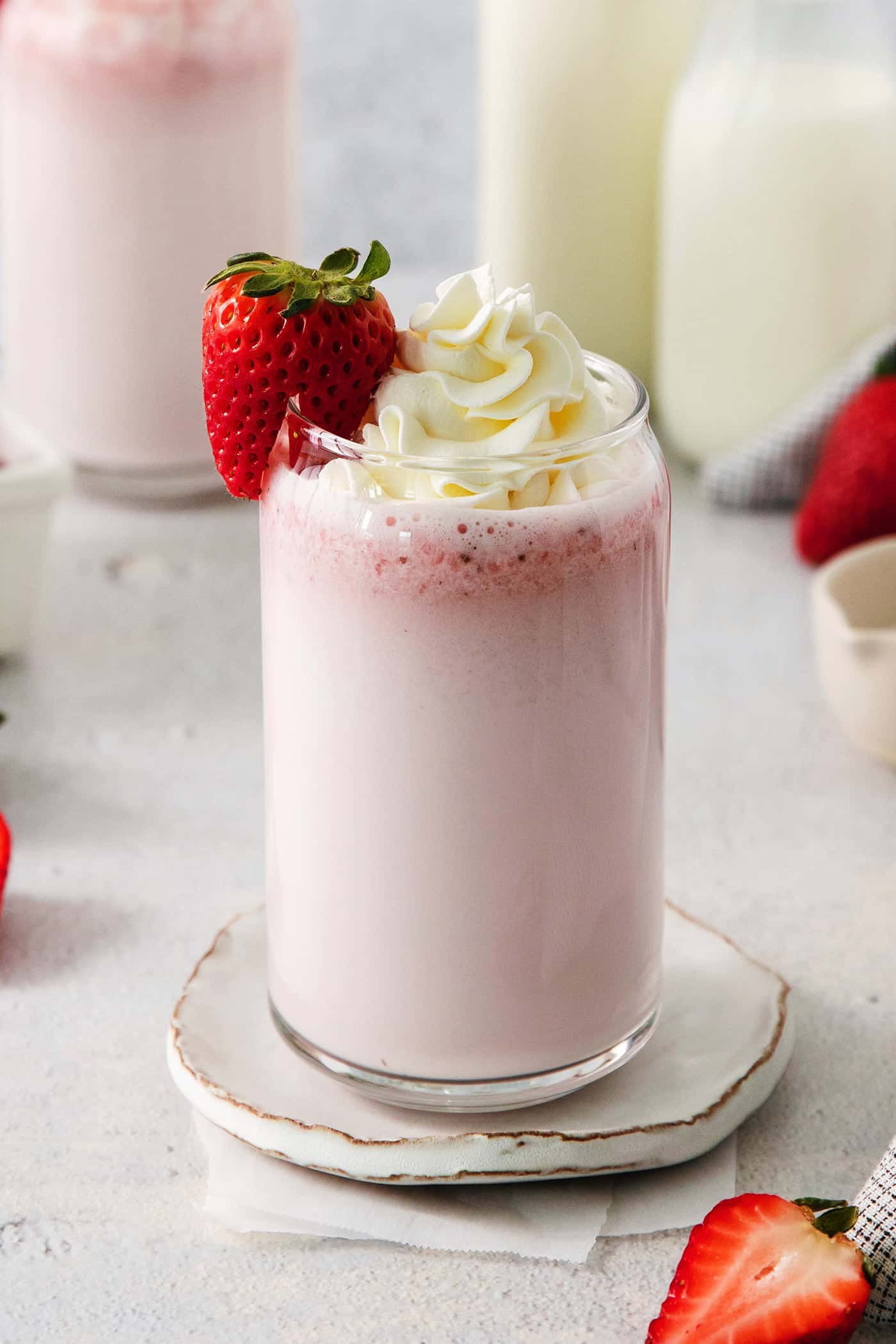Refreshing and beautiful, Strawberry Milk is beyond simple to make! You'll need just 4 ingredients and a few minutes to whip up glasses of this strawberry-laden drink. Glasses of strawberry milk with milk in the background.