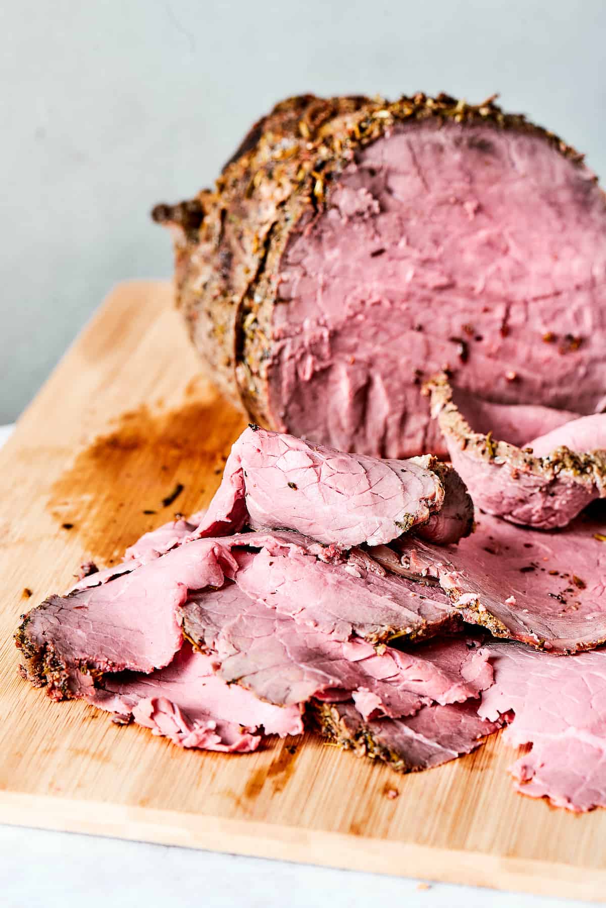 Loaded with lots of melted Swiss cheese, this Roast Beef Sandwich piles thinly sliced meat, fresh greens, and mayonnaise on a toasted bun. Sliced roasted beef on a platter.
